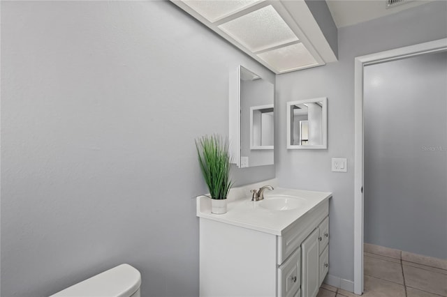 bathroom featuring toilet, vanity, and tile patterned floors