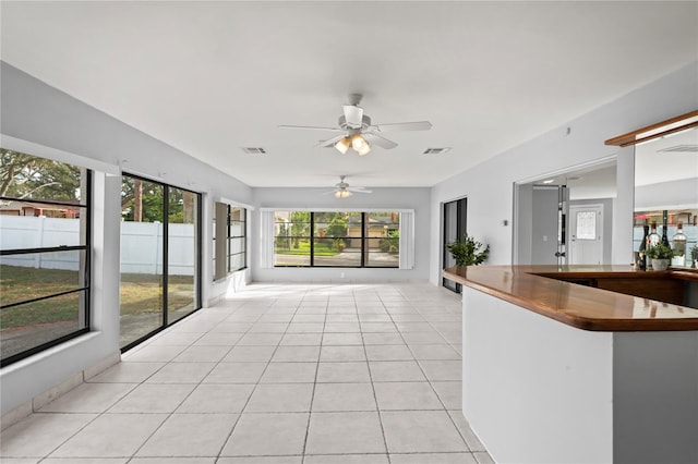 unfurnished sunroom with ceiling fan