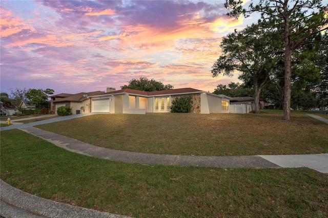 ranch-style home with a yard and a garage