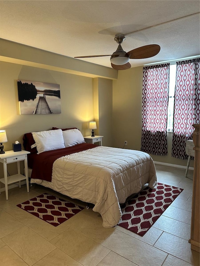 tiled bedroom featuring ceiling fan and a textured ceiling