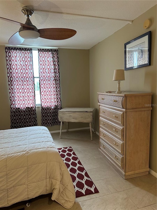 bedroom featuring ceiling fan, a textured ceiling, and light tile patterned floors