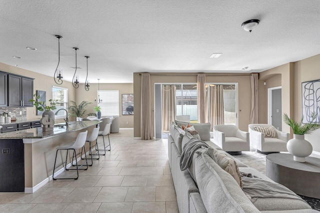 living room featuring plenty of natural light, light tile patterned flooring, and a textured ceiling