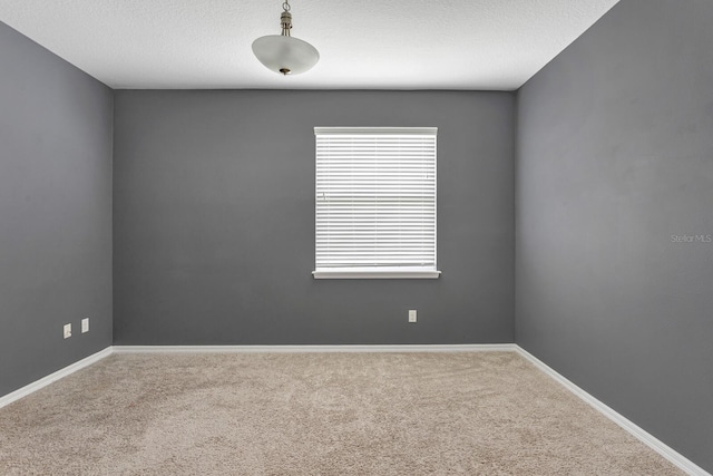 carpeted empty room featuring a textured ceiling