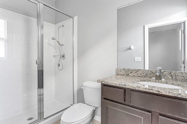 bathroom featuring vanity, toilet, and a shower with door