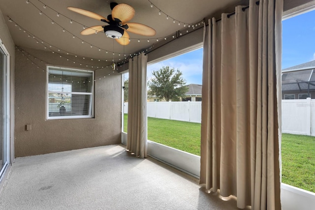 unfurnished sunroom with ceiling fan