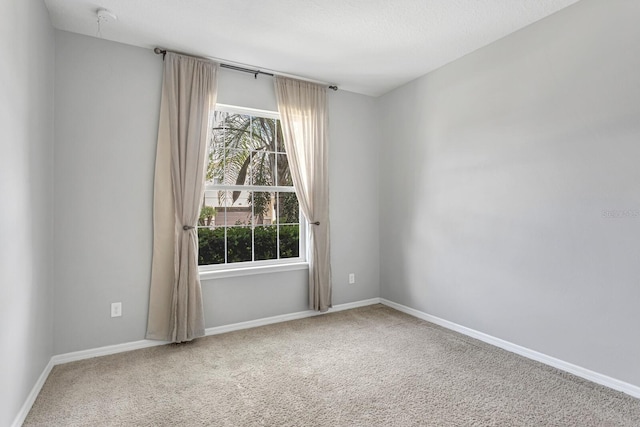 unfurnished room featuring carpet flooring and a textured ceiling