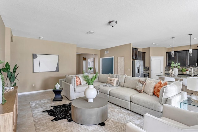 living room featuring sink and a textured ceiling