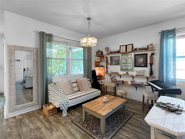 living room featuring dark hardwood / wood-style floors, a chandelier, and a wealth of natural light