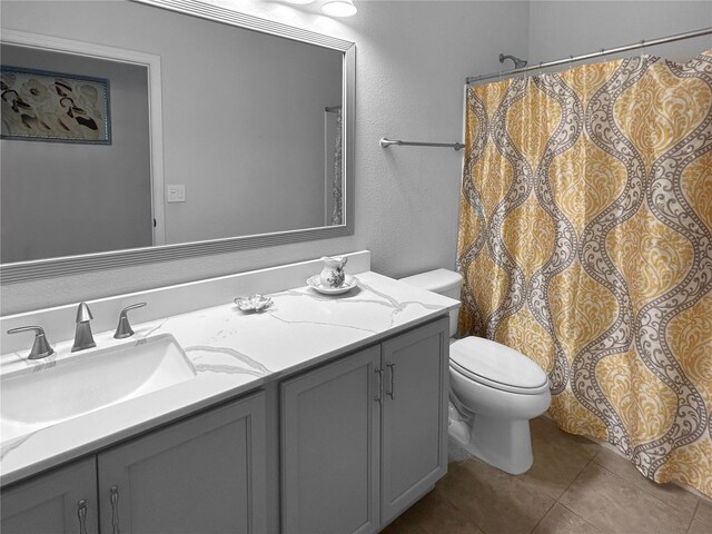 bathroom featuring vanity, toilet, and tile patterned flooring