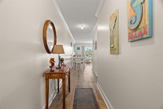 hall with ornamental molding, a textured ceiling, and hardwood / wood-style flooring