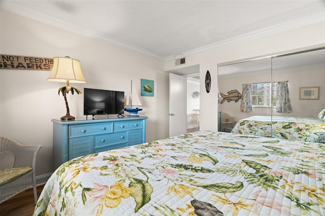 bedroom featuring a closet, a textured ceiling, hardwood / wood-style flooring, and crown molding