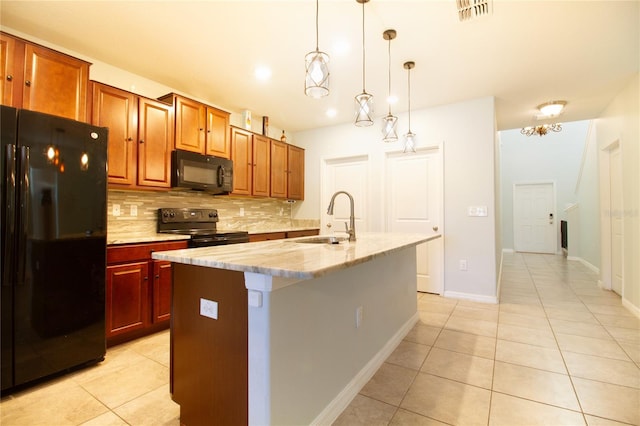 kitchen featuring sink, hanging light fixtures, a kitchen island with sink, decorative backsplash, and black appliances