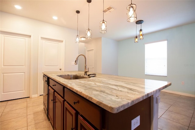 kitchen with stainless steel dishwasher, sink, pendant lighting, a center island with sink, and light tile patterned flooring