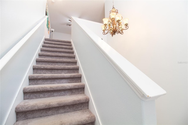 staircase featuring a chandelier