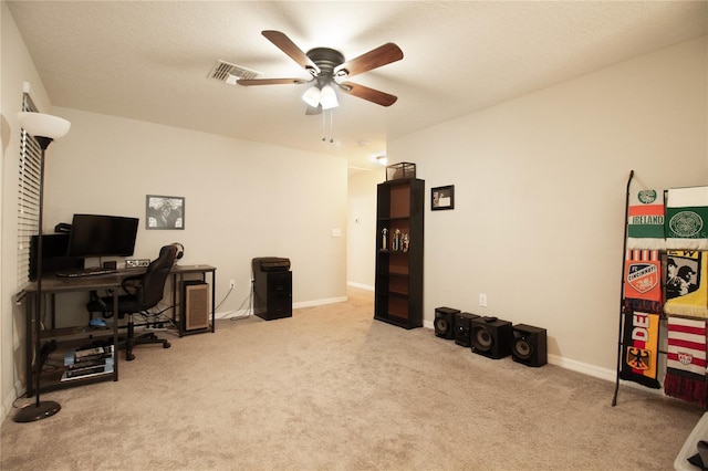 office area featuring a textured ceiling, ceiling fan, and light carpet