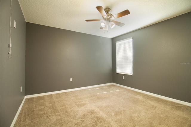 carpeted empty room with ceiling fan and a textured ceiling