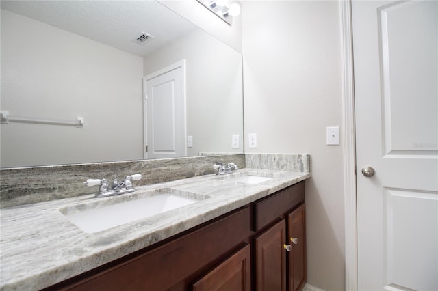 bathroom featuring a textured ceiling and vanity