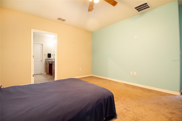 bedroom featuring light carpet, ensuite bath, and ceiling fan