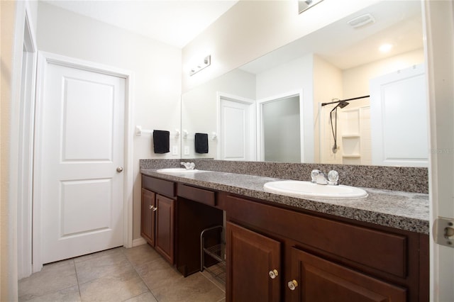 bathroom with a shower, vanity, and tile patterned floors