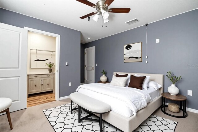 105 Cascade Bend Dr, Ruskin, FL 33570 - bedroom with light colored carpet, baseboards, ensuite bathroom, and a ceiling fan