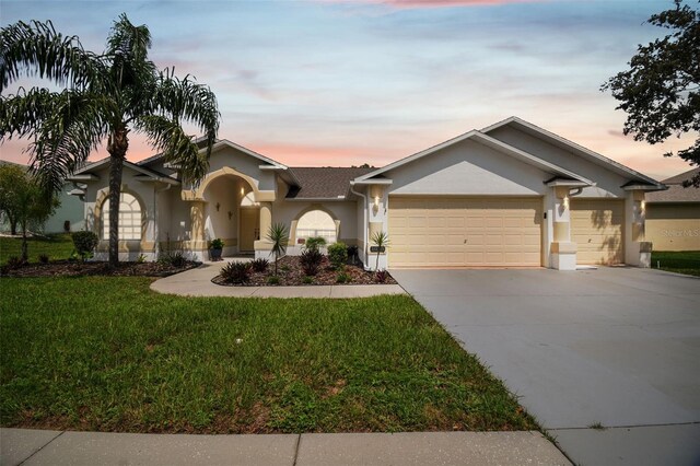 view of front facade featuring a lawn and a garage