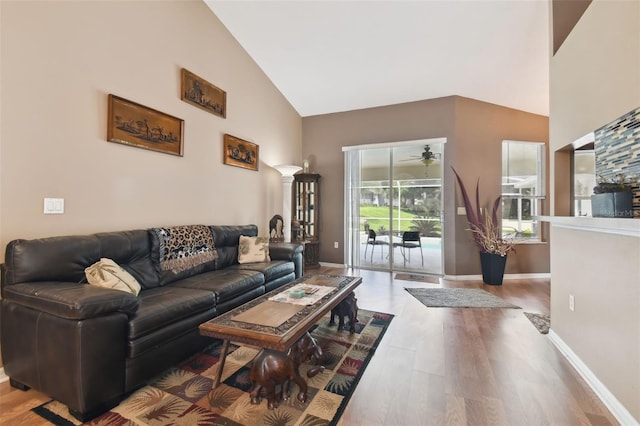 living room featuring hardwood / wood-style flooring, ceiling fan, and high vaulted ceiling