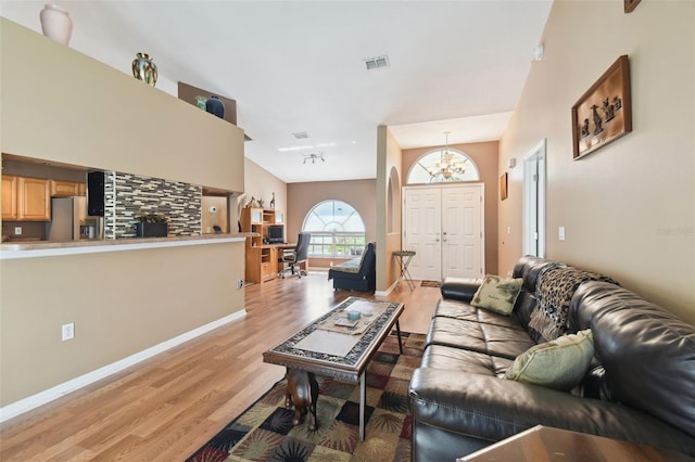 living room with a chandelier and light hardwood / wood-style floors