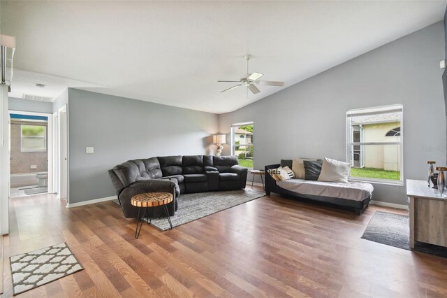 living room featuring vaulted ceiling, wood-type flooring, ceiling fan, and a healthy amount of sunlight