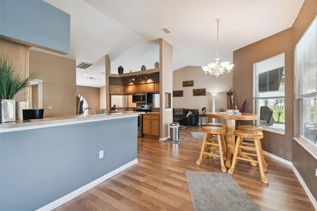 kitchen featuring hanging light fixtures, appliances with stainless steel finishes, a chandelier, and light hardwood / wood-style floors