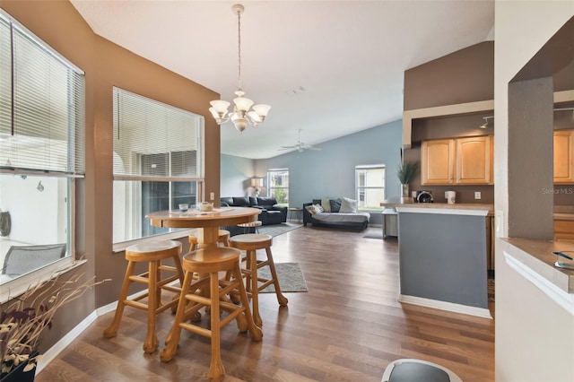 dining area with lofted ceiling, ceiling fan with notable chandelier, and dark hardwood / wood-style flooring