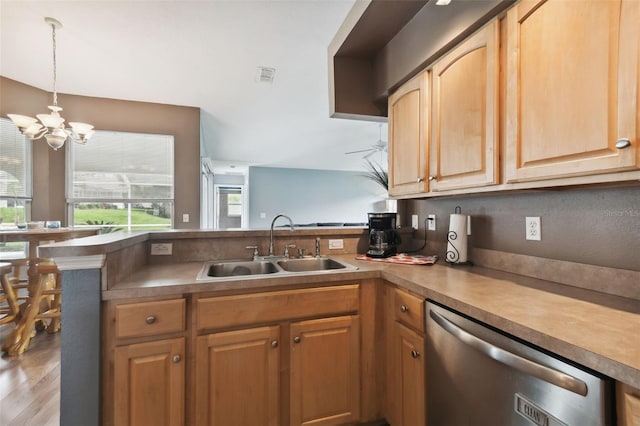 kitchen with pendant lighting, sink, ceiling fan with notable chandelier, stainless steel dishwasher, and kitchen peninsula