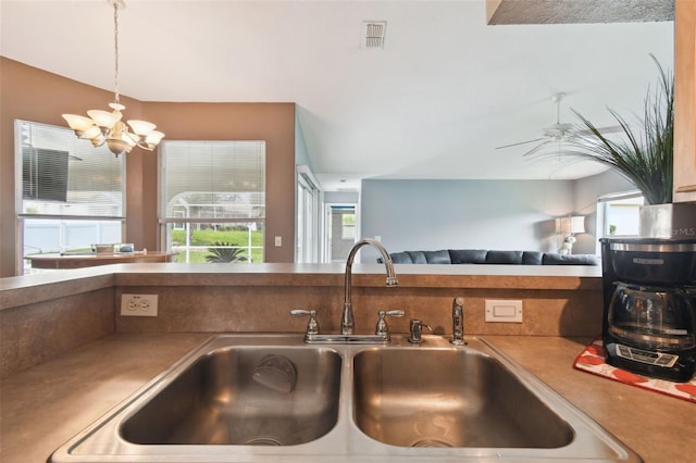 kitchen featuring ceiling fan with notable chandelier, plenty of natural light, sink, and hanging light fixtures