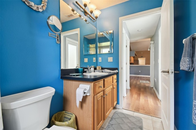 bathroom with vanity, tile patterned floors, toilet, and an inviting chandelier