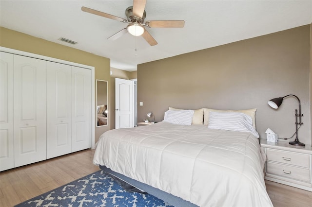 bedroom featuring wood-type flooring, ceiling fan, and a closet