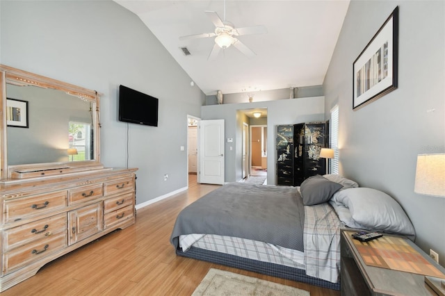 bedroom with ceiling fan, connected bathroom, high vaulted ceiling, and light hardwood / wood-style flooring