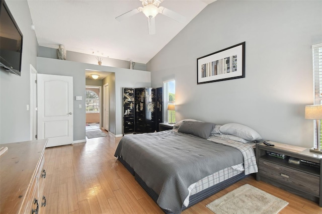 bedroom featuring light hardwood / wood-style flooring, high vaulted ceiling, and ceiling fan