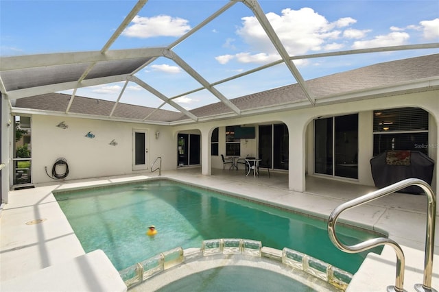 view of pool with an in ground hot tub, glass enclosure, and a patio