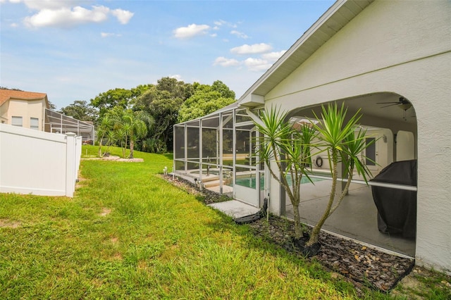 view of yard with a lanai, a patio, and ceiling fan