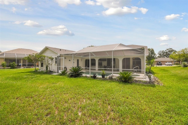 rear view of house featuring a lanai and a lawn