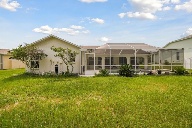 back of property featuring a yard and glass enclosure