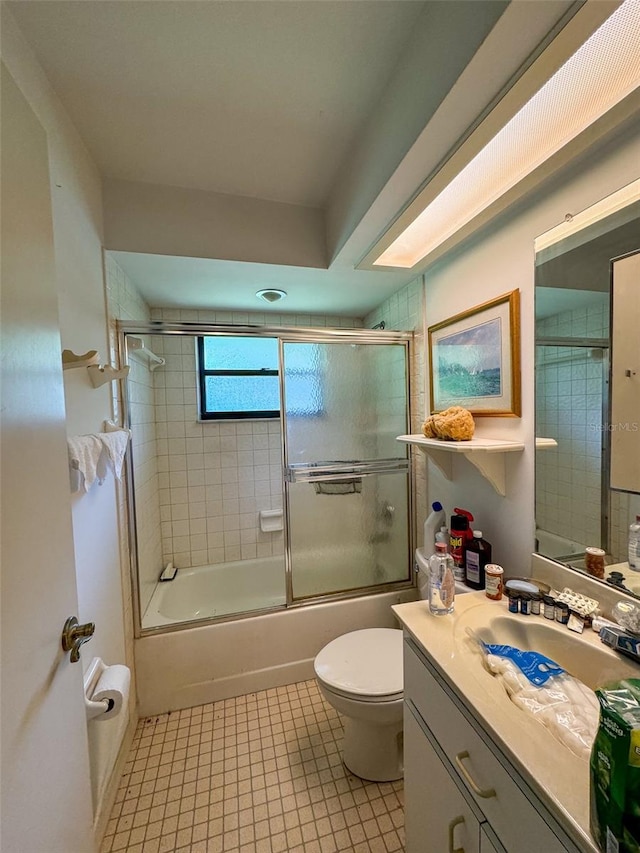 full bathroom featuring enclosed tub / shower combo, vanity, toilet, and tile patterned flooring