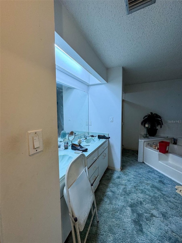 bathroom featuring a textured ceiling and double sink vanity