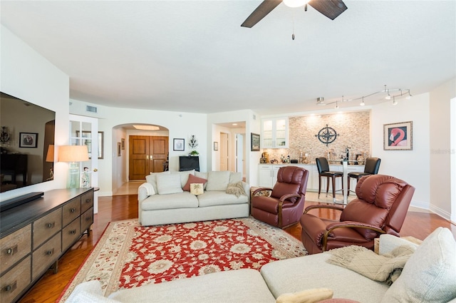 living room with ceiling fan, track lighting, and wood-type flooring