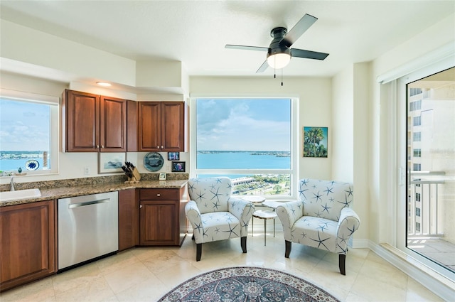 kitchen featuring ceiling fan, a water view, light tile patterned flooring, stainless steel dishwasher, and sink