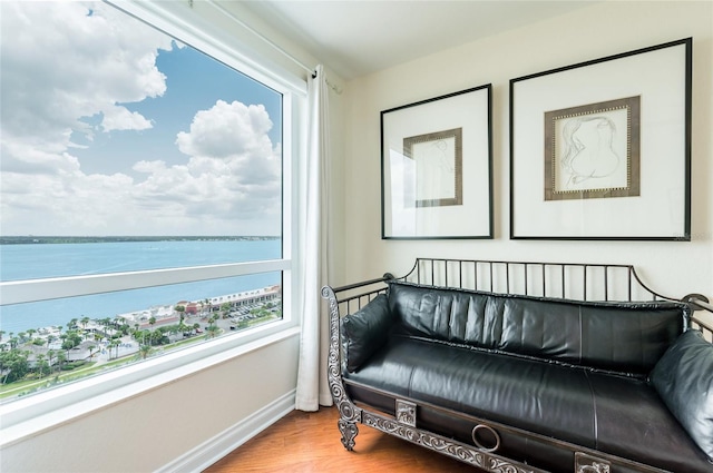 sitting room with a water view and hardwood / wood-style floors