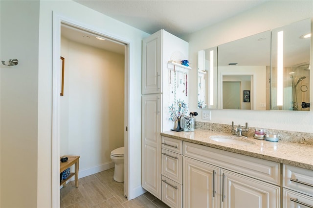 bathroom featuring toilet, tile patterned floors, and vanity