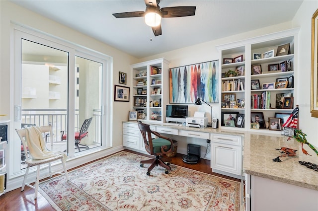 office space with ceiling fan, built in desk, and light hardwood / wood-style floors