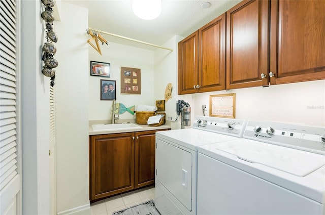 laundry room with washing machine and dryer, sink, light tile patterned floors, and cabinets