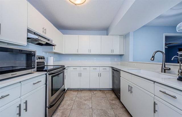 kitchen featuring light tile patterned floors, appliances with stainless steel finishes, sink, and white cabinets