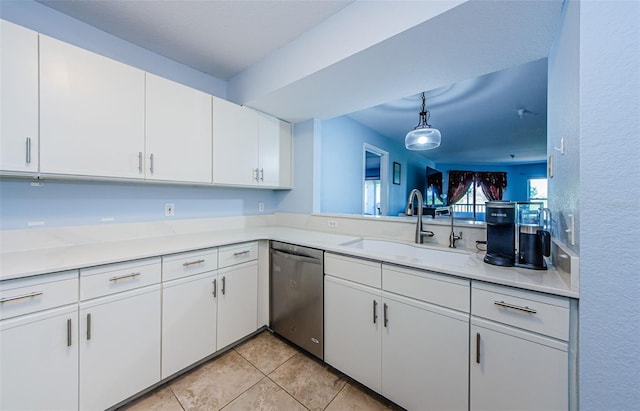 kitchen with light tile patterned flooring, decorative light fixtures, white cabinetry, sink, and stainless steel dishwasher